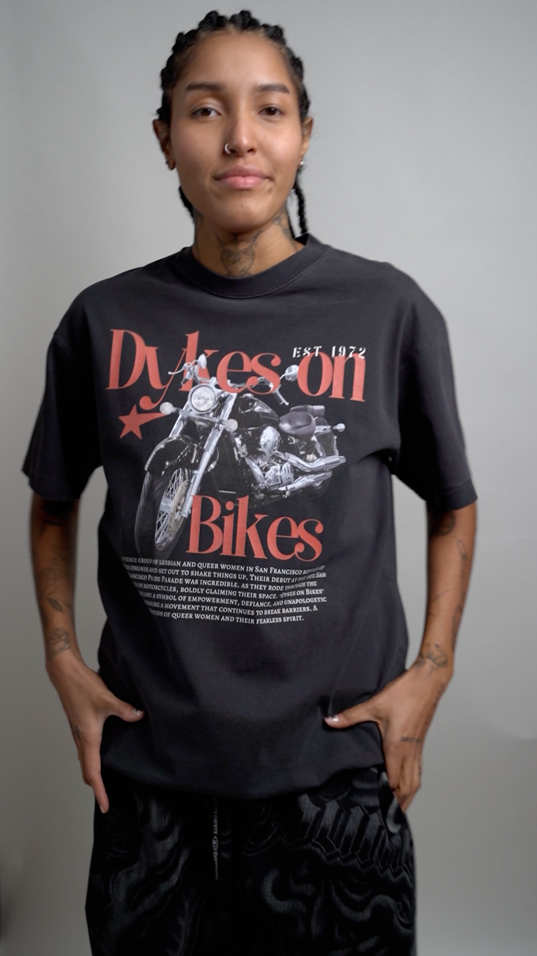 Pride T Shirts Tattooed Man with Black Oversized Tee with striking yellow text Rebellion is in my Roots with roots graphic as a protest tee