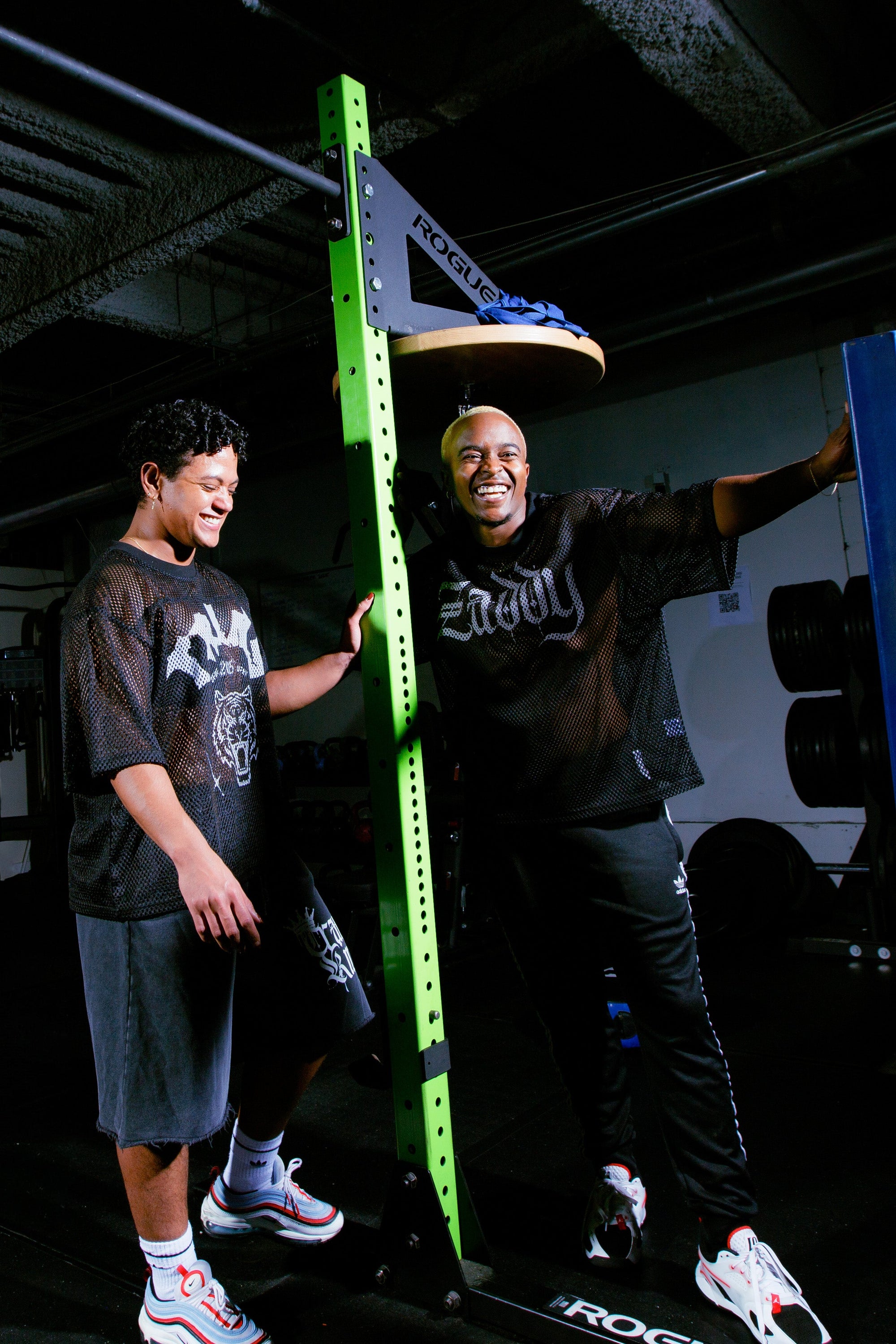 Black man with flat brim hat and black t-shirt with a retro purple jacket. The t-shirt says Trans King with a chrome crown for Trans Pride, Enby Pride, Transmasc Pride and Nonbinary Pride