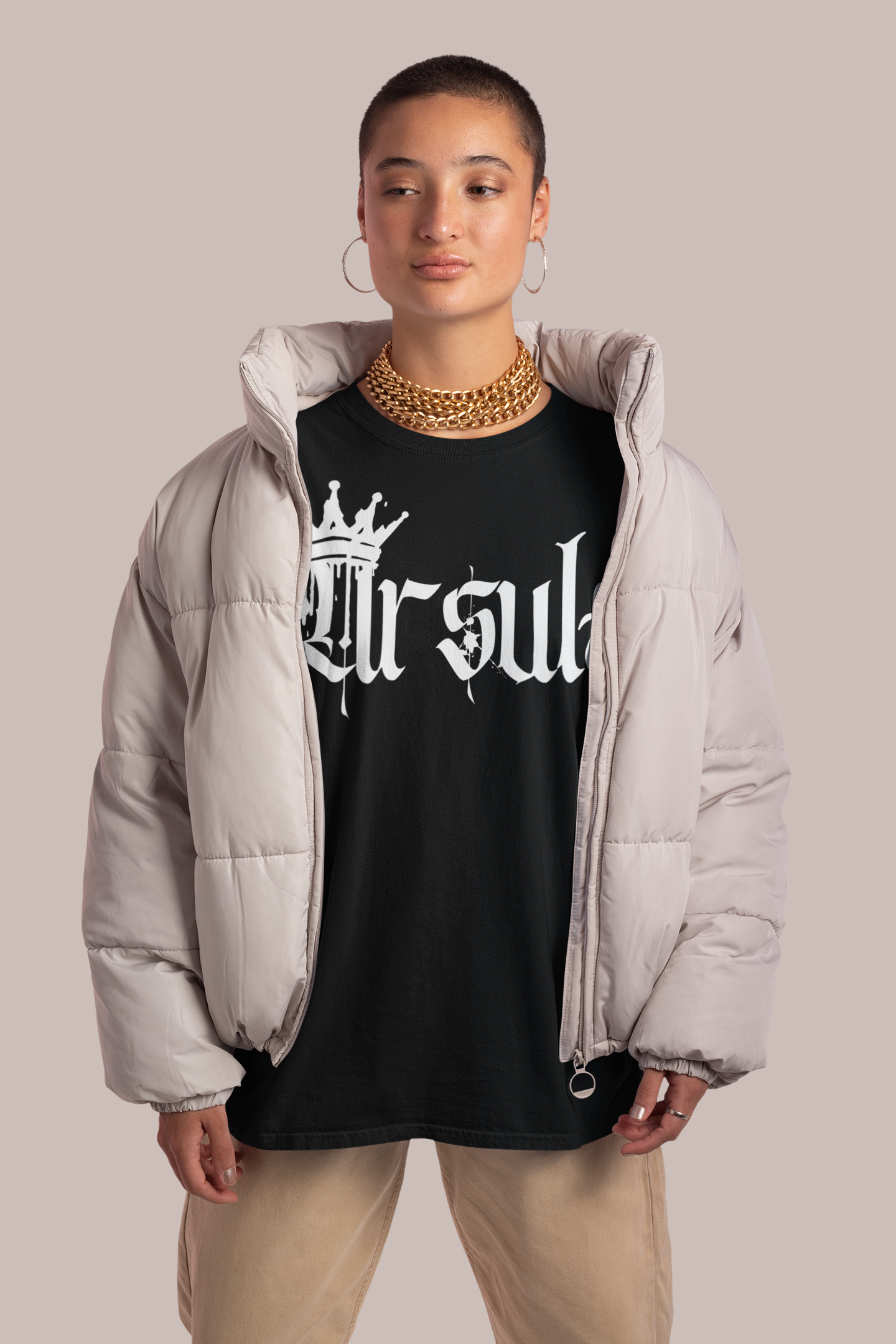 Lesbiana Pride Latina wearing a puffy coat and a black oversized tee that has Ursula across the chest in white gothic text with a spray paint crown