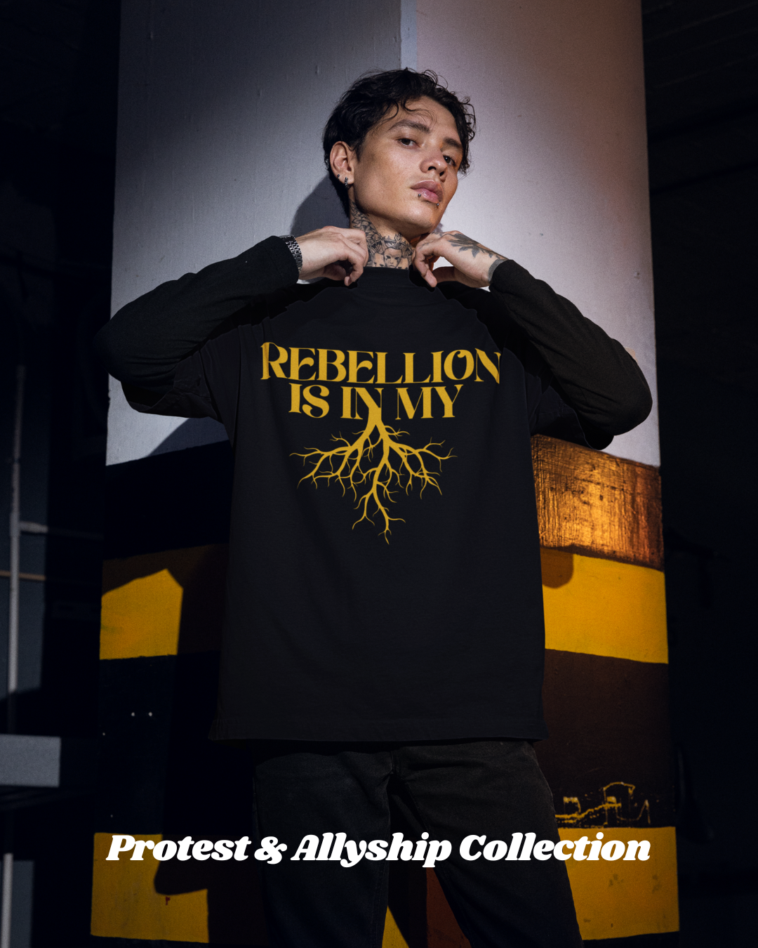 Person wearing a black sweatshirt with 'REBELLION IS IN MY' text and yellow design, standing against a dark background.