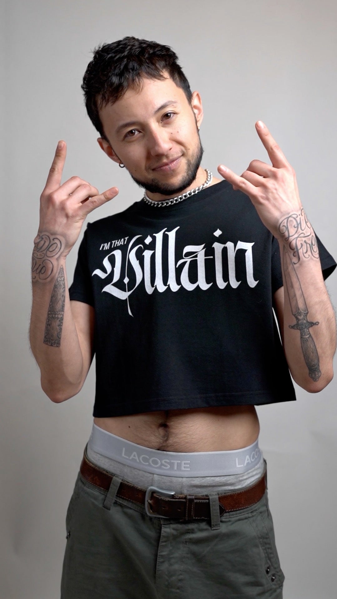 Man wearing a black 'Willian' t-shirt with visible tattoos and Lacoste underwear.
