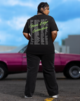 Back of Oversized Black Tee with list of Banned Words in 4 columns with Neon Green Cursive Lettering saying Nova Edge Collective across the back