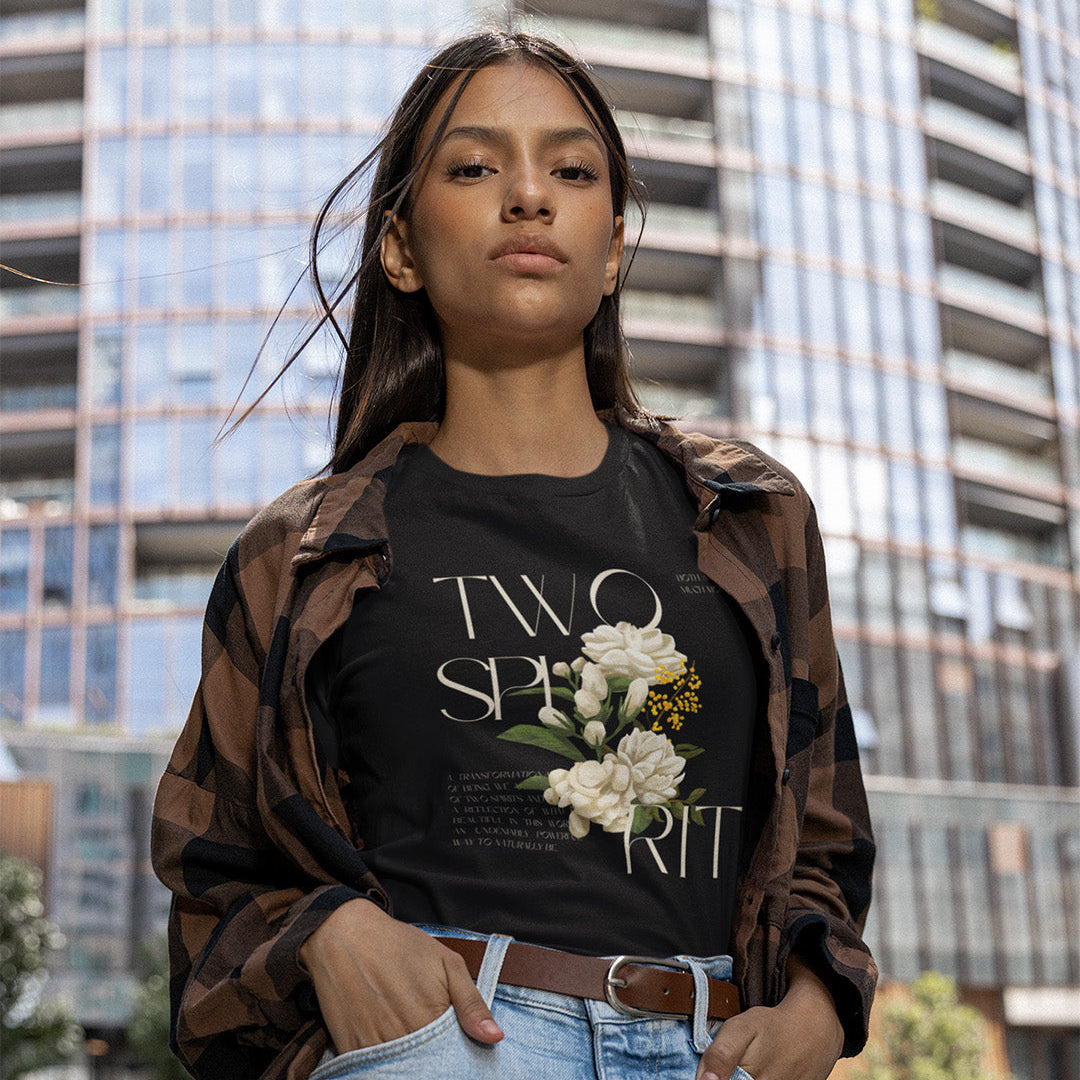 Woman wearing a black t-shirt with floral design and plaid shirt in an urban setting